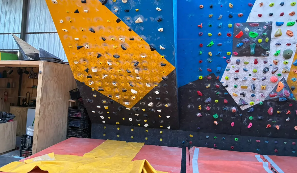 El panel amarillo y azul con las tablas de presas en cuadrícula, y el muro de colores a su derecha